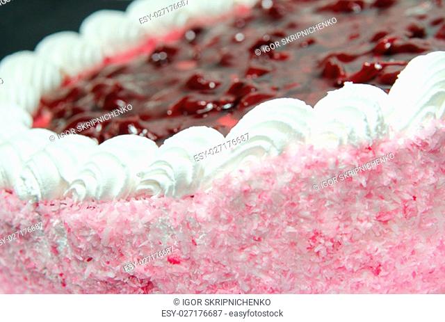 Side view of jelly cake with pink and white coconut flakes cream