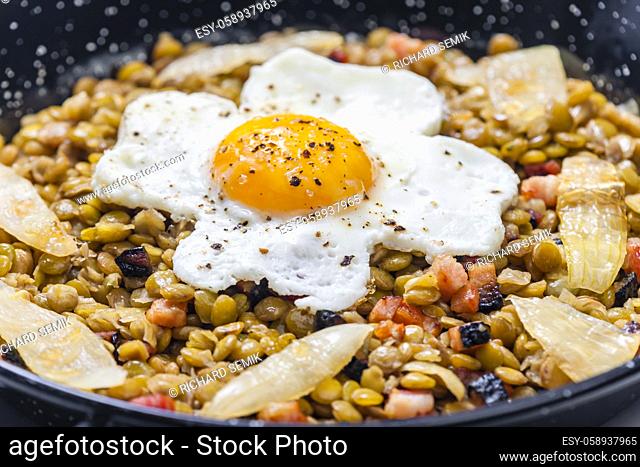 lentils with smoked meat and onion served with fried egg