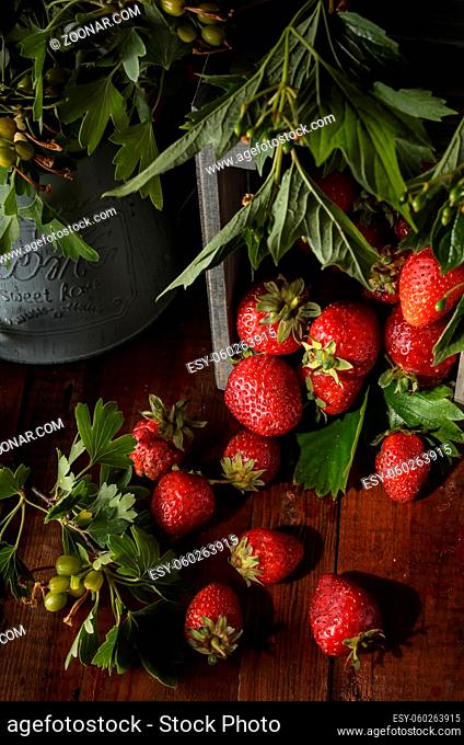 berries of ripe strawberries on a dark wooden background in a rustic style