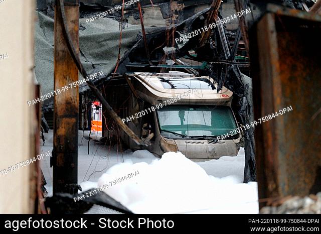 18 January 2022, North Rhine-Westphalia, Bergisch Gladbach: A mobile home is surrounded by firefighting foam in a burned-out warehouse