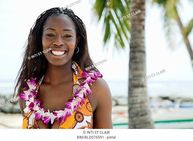 African woman wearing lei on beach