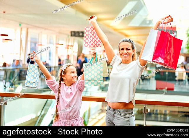 Mutter und Tochter beim Shopping im Einkaufszentrum mit vielen Einkaufstüten