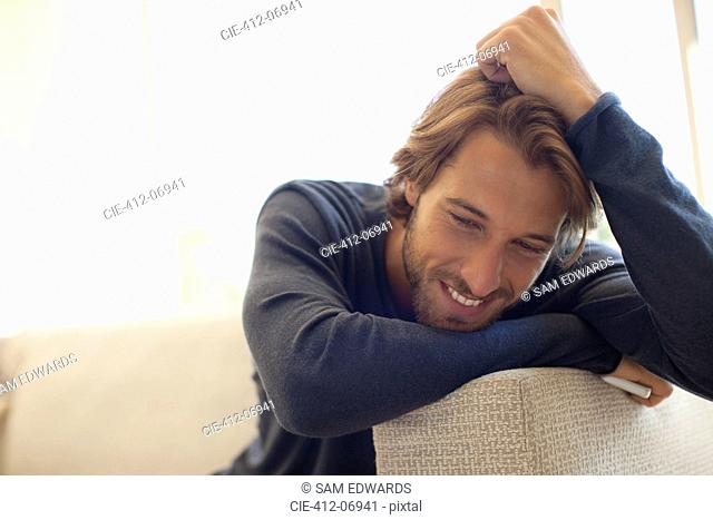 Man leaning on arm of sofa