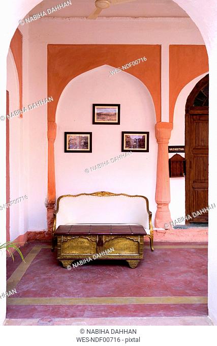 India, Rajasthan, Alwar, Heritage Hotel Ram Bihari Palace, Corridor with sofa and old table