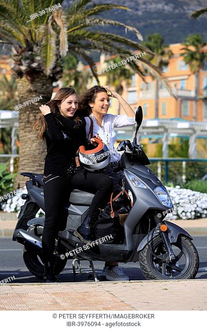 Two girlfriends, teenagers, with a scooter, Menton, Alpes-Maritimes, Provence-Alpes-Côte d'Azur, France