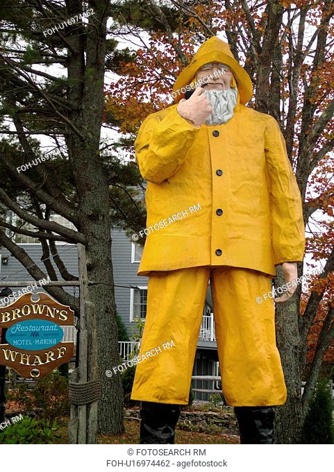 Booth Bay Harbor, ME, Maine, fishing village, Brown's Wharf, statue of a fisherman in a yellow rainsuit outside Brown's Wharf Restaurant and Marina