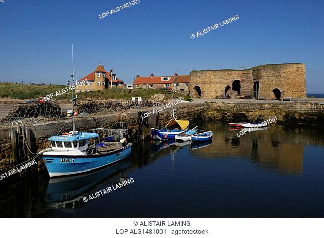 England, Northumberland, Beadnell. Small boats in Beadnell Harbour and the remains of the lime kilns, the earliest of which dates back to 1789