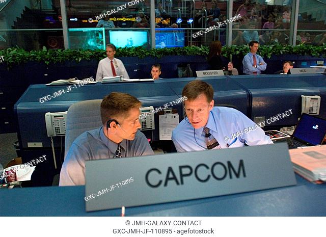 At the CAPCOM console in the space shuttle flight operations control room of Houston's Mission Control Center, astronauts Christopher J