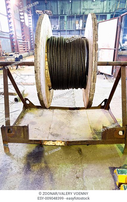 wooden reel with steel rope in warehouse