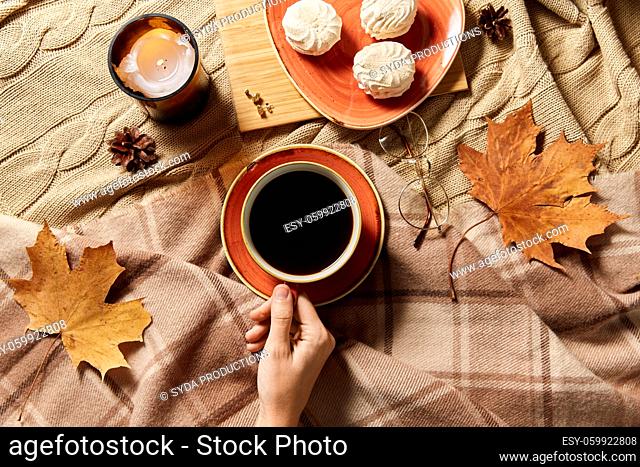 cup of coffee, autumn leaves and candle in bed
