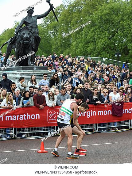 Matthew Rees (left) of Swansea Harriers unselfishly helps David Wyeth of Chorlton Runners reach the finish line during the Virgin Money London Marathon...