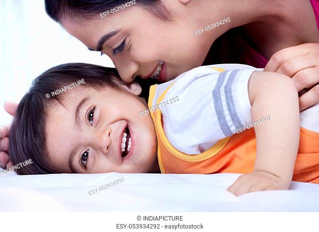 Mother and son smiling on a bed