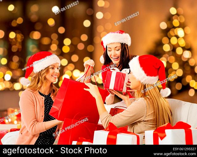 happy women in santa hats with christmas presents