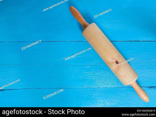 Nudelholz auf blauem Holz als Hintergrund
