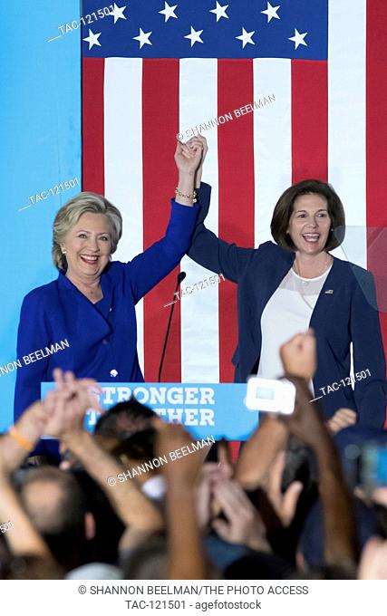 Catherine Cortez Masto (r) and Hillary Clinton hold hands together in the air to the crowd at the canvass kick off on November 2nd 2016 at the Plumbers and...