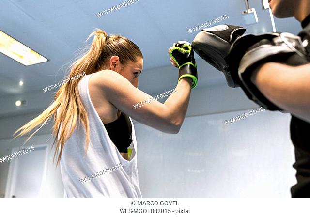 Young woman in gym doing boxing training