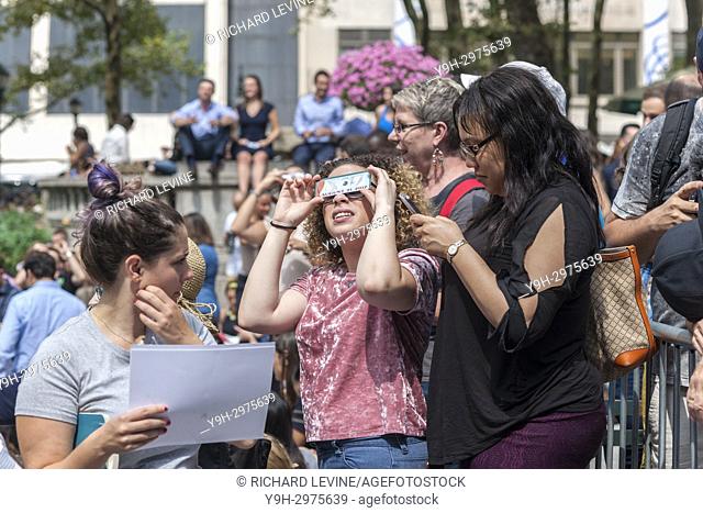 Thousands of the curious congregate in Bryant Park to watch the partial solar eclipse occurring in New York on Monday, August 21, 2017