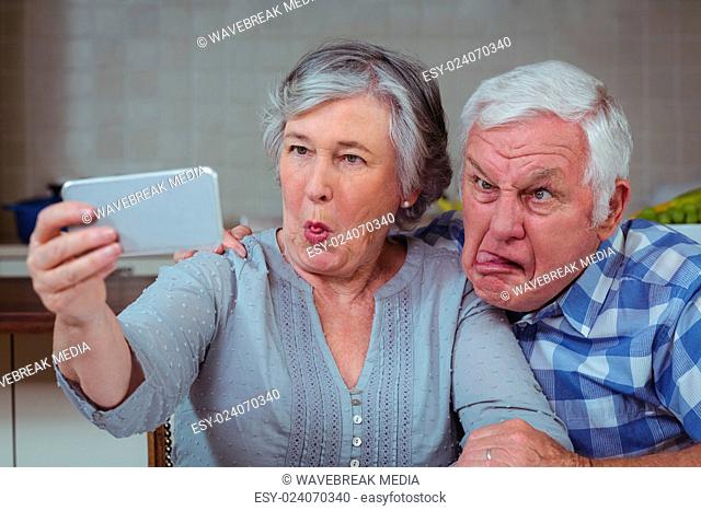 Senior couple making faces while taking selfie