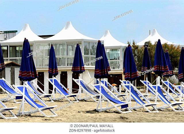 Beach sun umbrellas and deck chairs in front of a modern Italian Beach Bar Restaurant, Cecina Mare, Tuscany Italy