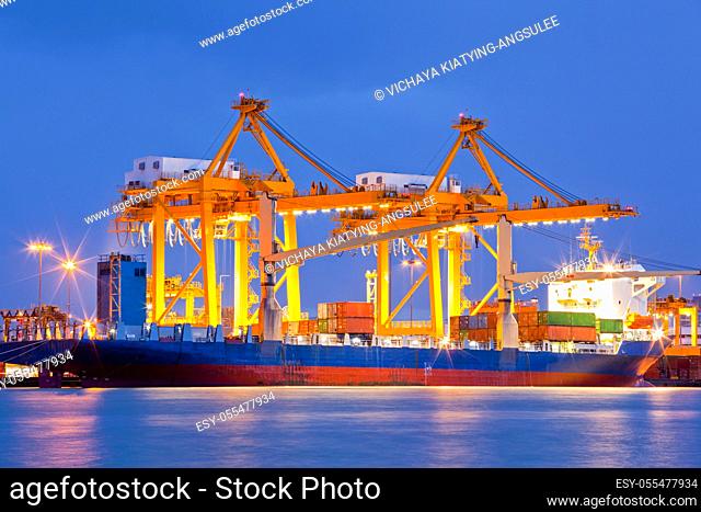 Container Cargo freight Industrail ship with working crane bridge unloading and loading goods in Bangkok shipyard Terminal at dusk for Logistic Import Export...