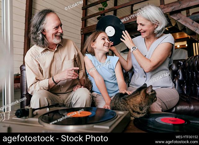 Grandparents enjoying music with granddaughter at home