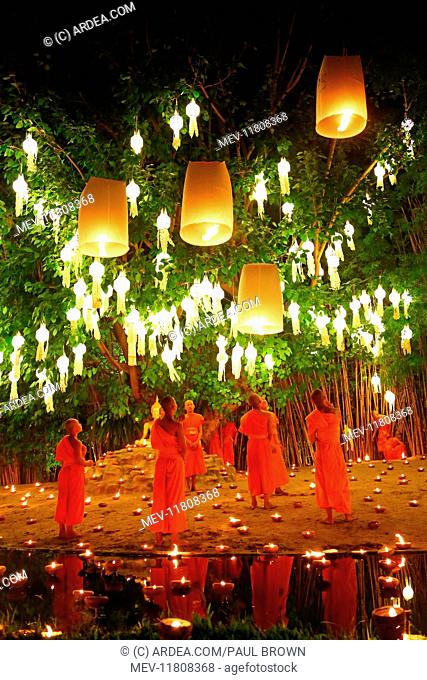 Monks celebrate the Loy Krathong festival at Wat Phan Tao Temple, Chiang Mai, Thailand with candles and sky lanterns in a sombre and moving ceremony which...