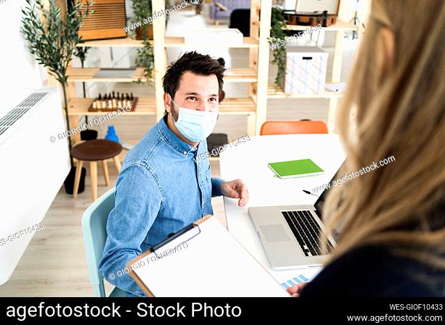 Business people wearing protective masks¶ÿtalking in office¶ÿ