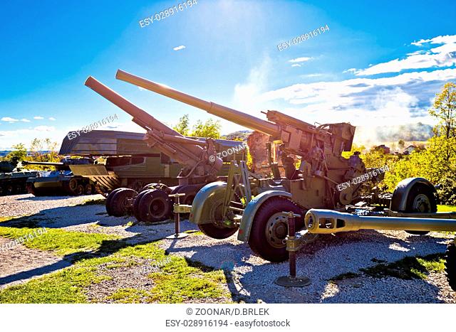 Military tanks and cannons with sun rays