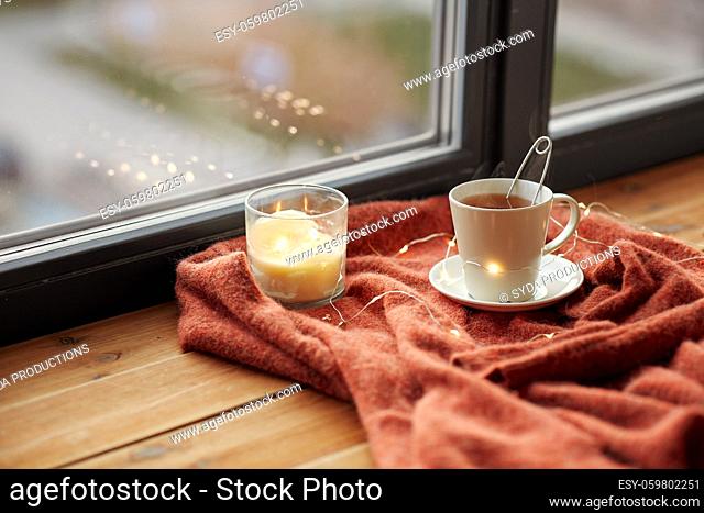 cup of tea and candle on window sill
