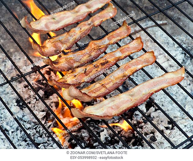 Bacon slices grilling on a Fire