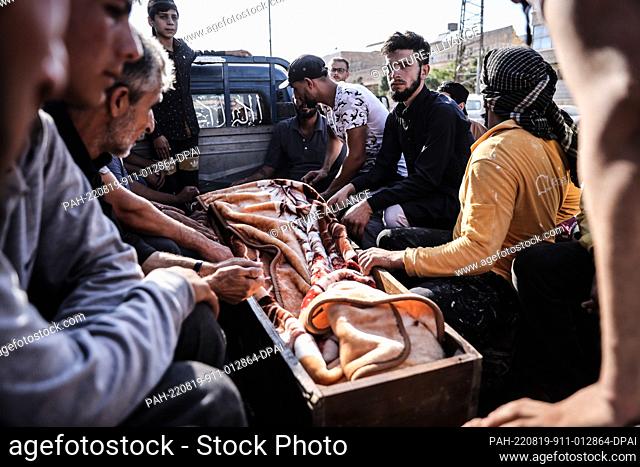 19 August 2022, Syria, Al-Bab: Syrians prepare to bury the victims of a missile attack that targeted a popular market in the city of al-Bab