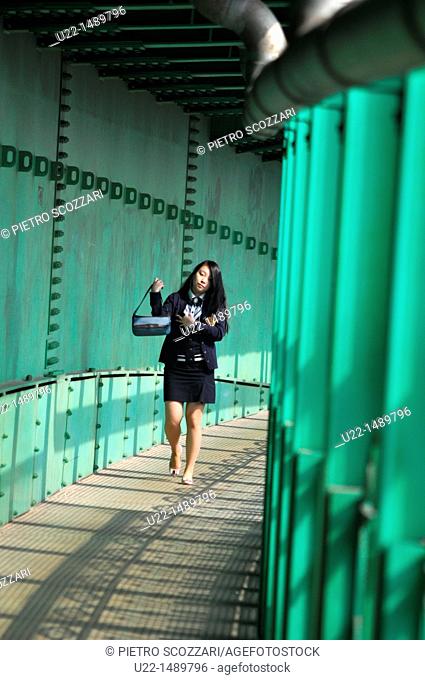 Woman crossing the trains tracks along a footbridge in Nam-gu neighborhood, Busan, South Korea