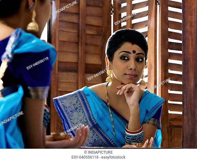 Bengali woman looking at herself in a mirror