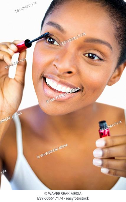Happy woman using mascara for her eyelashes