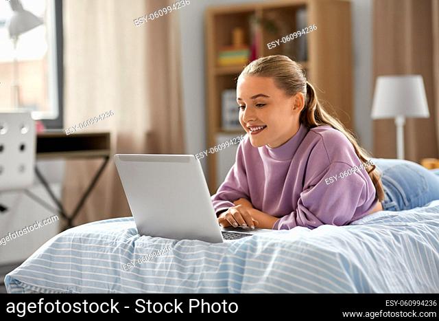 smiling girl with laptop computer at home