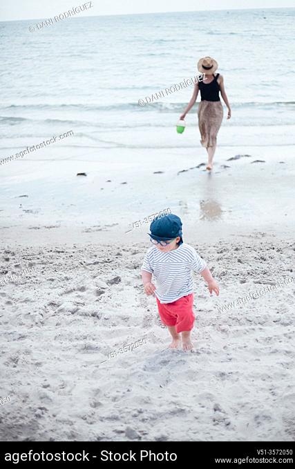 2 years old boy with his mother at the beach