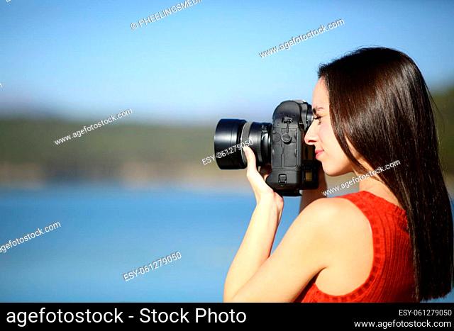 Woman taking photos with dslr camera in a lake