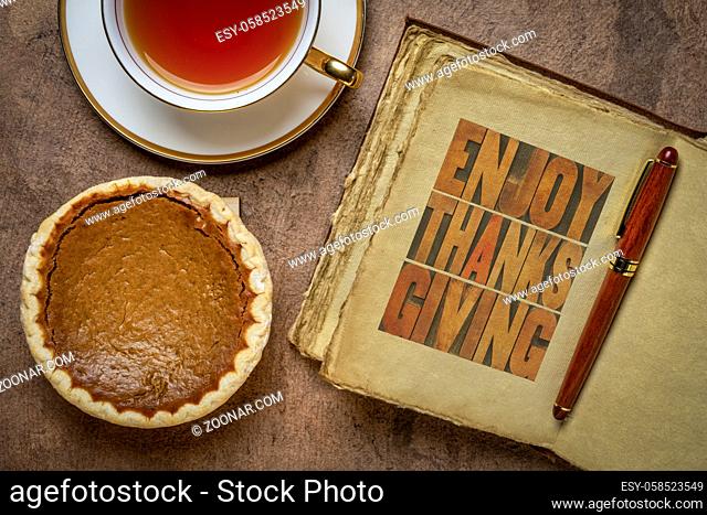 Enjoy Thanksgiving - letterpress typography in a retro, leather-bound journal with a pumpkin pie and a cup of tea, fall holiday greetings
