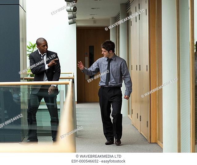 Young businessmen saying goodbye in a corridor