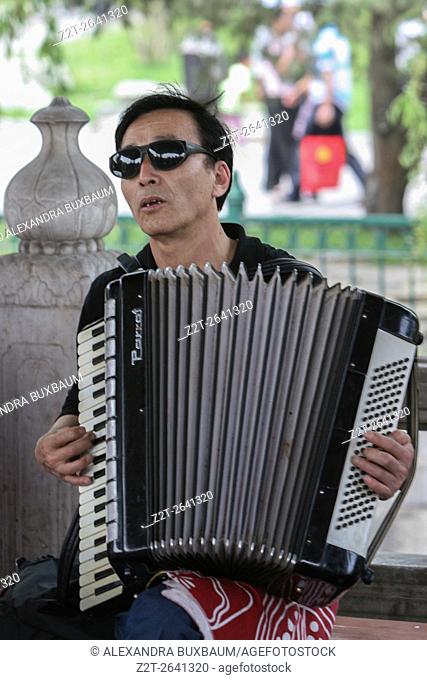 A man plays the accordian in Bei Hai Park, Beijing, China
