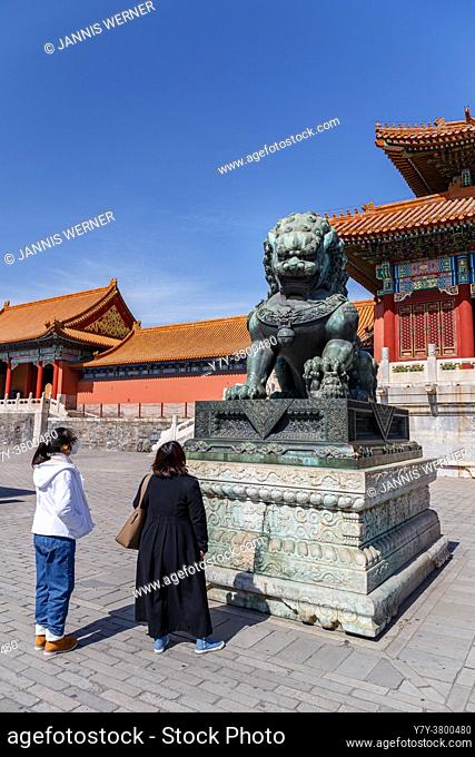 Tourists gaze at Ming-era Chinese imperial guardian lion bronze iat the Forbidden City in Beijing, China in March 2018