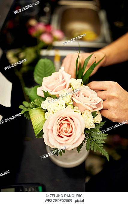 Close-up of florist arranging flowers in flower shop