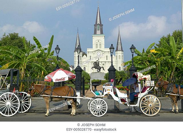 Horse Carriage and tourists in front of Andrew Jackson Statue & St. Louis Cathedral, Jackson Square in New Orleans, Louisiana