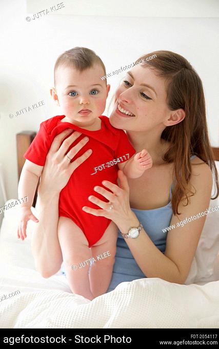 Mother in Bed Holding Baby Girl