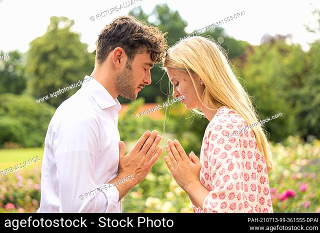 PRODUCTION - 03 July 2021, Lower Saxony, Oldenburg: ILLUSTRATION - A man and a woman do a Namaste greeting. (posed scene) Photo: Mohssen Assanimoghaddam/dpa