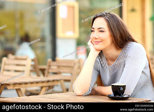 Confident young woman looking away sitting on a coffee shop terrace