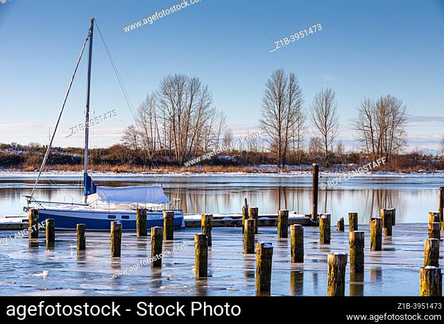 Winter scene with a small sailboat at a dock in Steveston British Columbia Canada