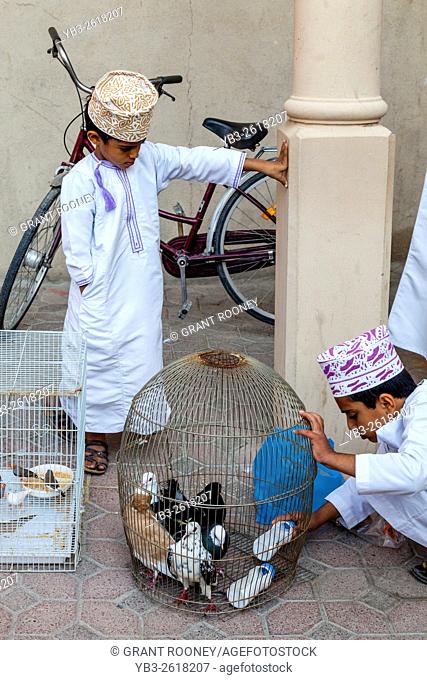 An Omani Boy Sells Exotic Birds At The Friday Bird Market, Nizwa, Ad Dakhiliyah Region, Oman