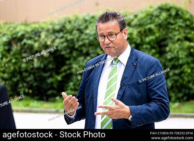 04 August 2021, Baden-Wuerttemberg, Freiburg: Peter Hauk (CDU), Minister of Forestry of Baden-Württemberg, stands in front of a house in timber construction and...