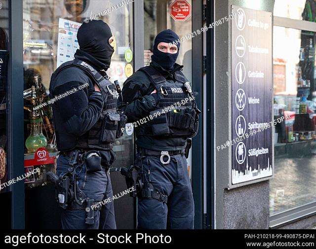 18 February 2021, Berlin: Police officers stand in front of a convenience store in Neukölln during a raid. With a large-scale raid